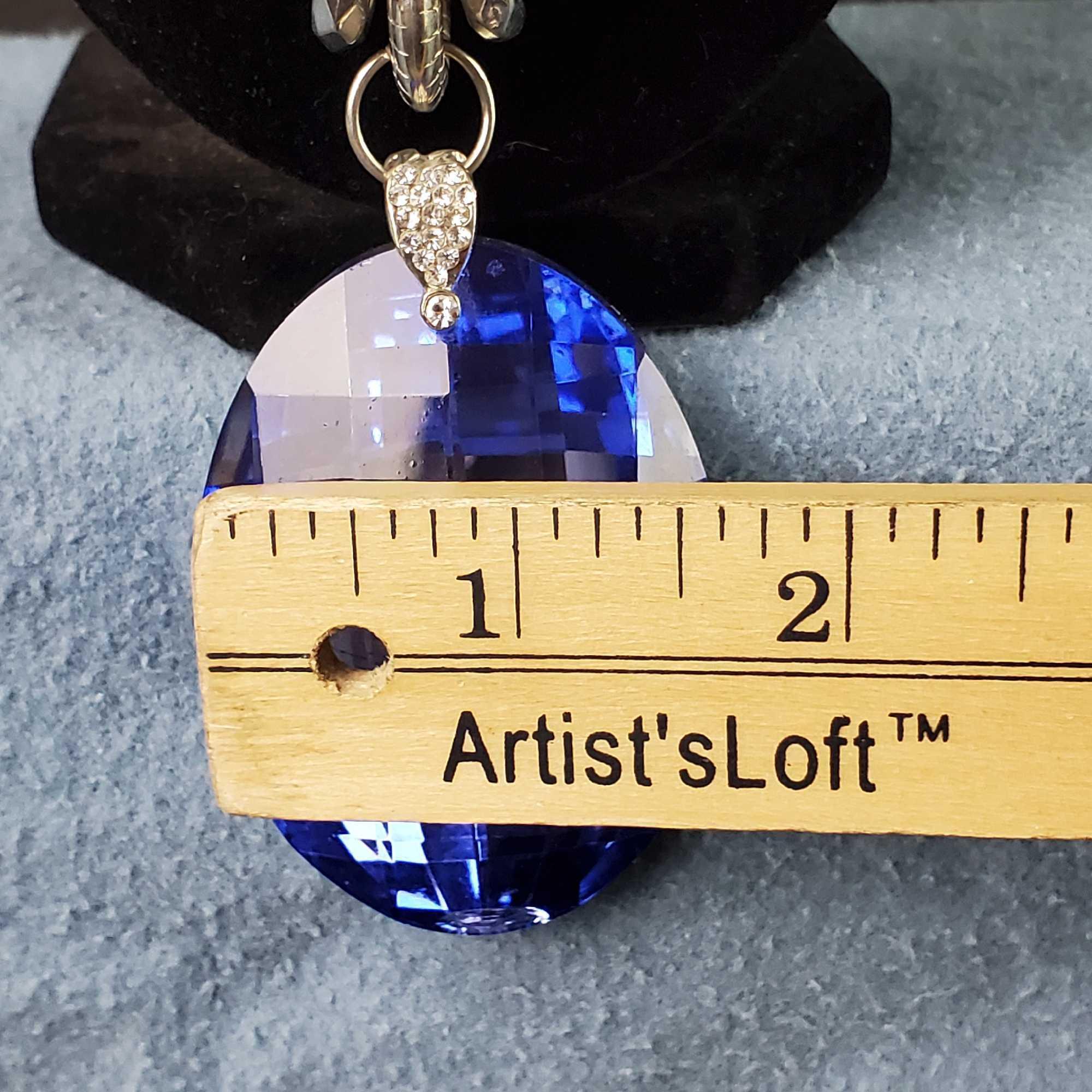 Unique silver tone necklace with large flashy blue pendant