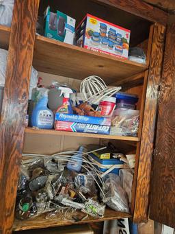 Cabinet contents including banners and vacuum cleaner on floor.