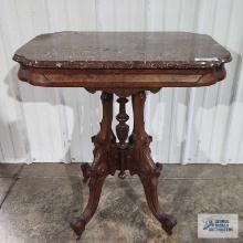 Antique stand with marble top and wooden wheels. 31 in. tall by 28 in. wide by 19 in. deep