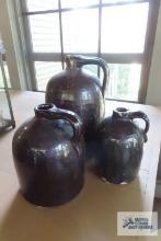 Three jugs. one has been repaired and one has chips.