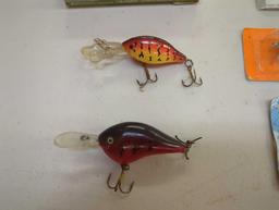 Container and contents including various fishing lures of similar style. Comes as is shown in