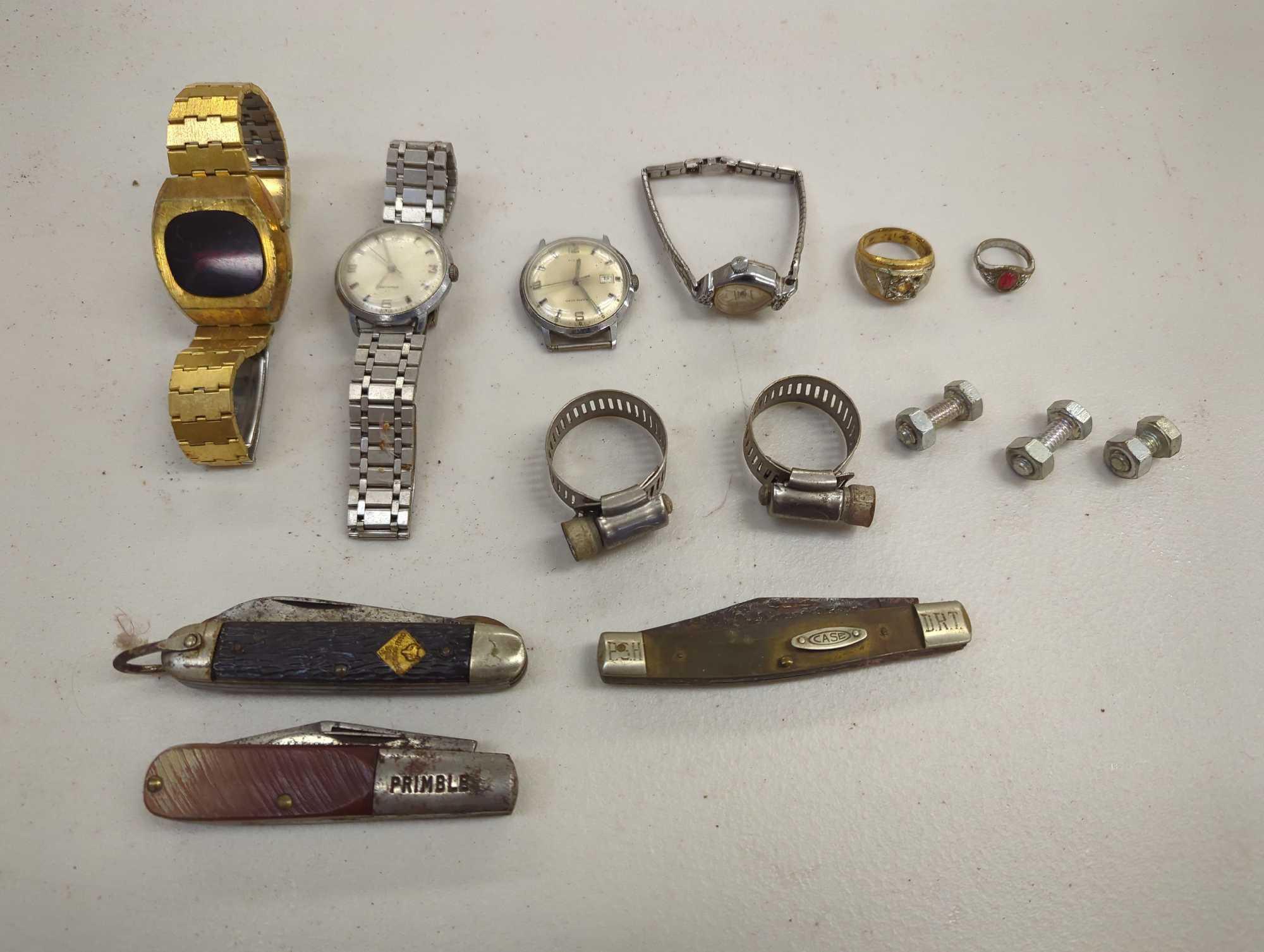 Black container including wrist watches, pocket knives, and rings. Comes as is shown in photos.