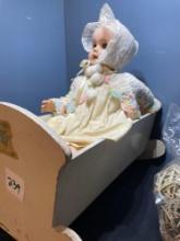 vintage doll in rocking cradle, decorative orbs and bag of vintage linen