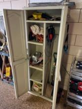 Plastic cabinet with shovels, extension cord, garage items