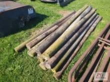 Pile of wooden fence posts, with plastic water bucket